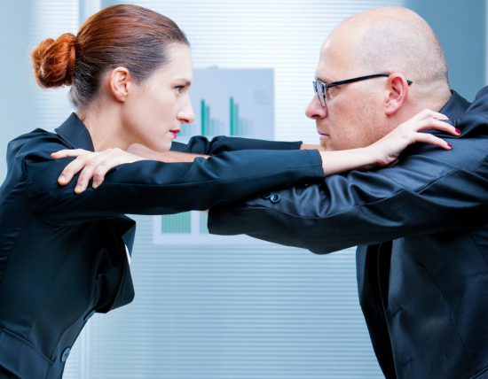 business woman and business man fighting facing each other